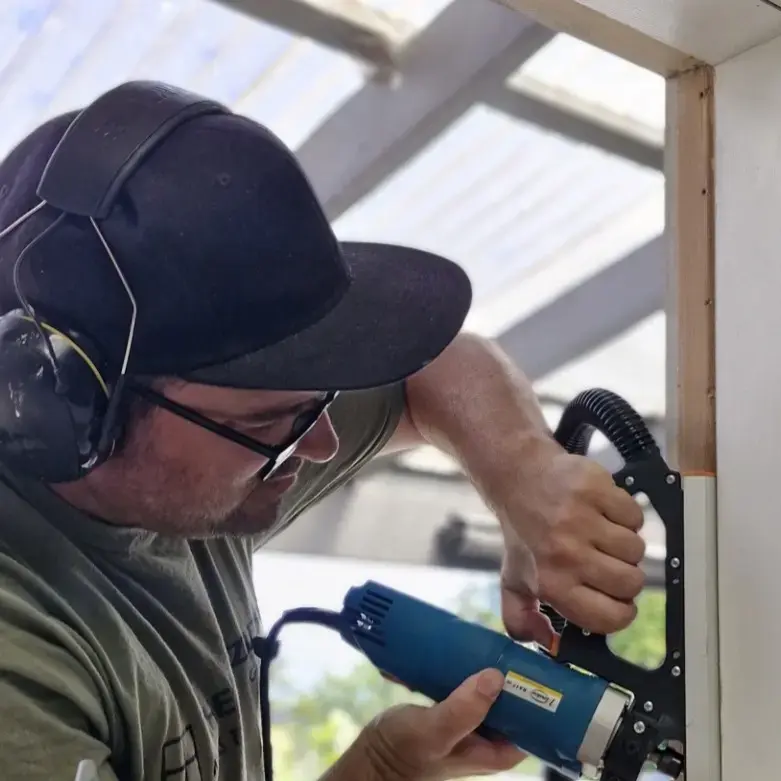 Ryan Bramwell from The Glaziers installing retrofit double glazing into an existing timber window in an Auckland home